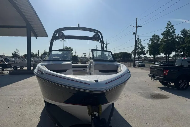 Slide: The Image of 2018 Tahoe 700 TF boat parked outdoors under clear sky. - 2