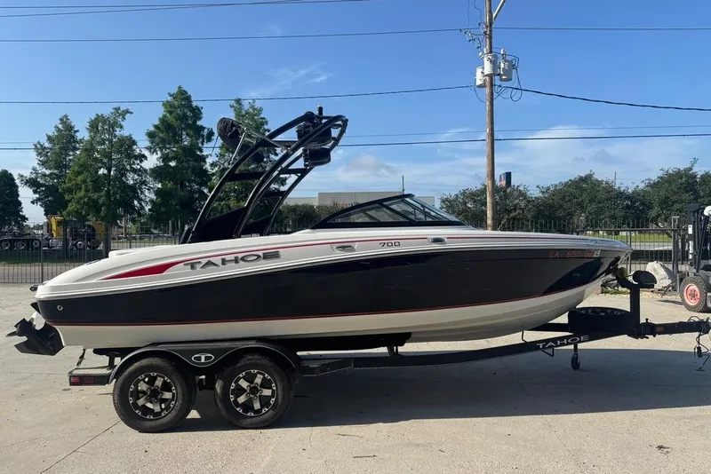 Slide: The Image of 2018 Tahoe 700 TF boat on trailer, black and white design, parked outdoors. - 4