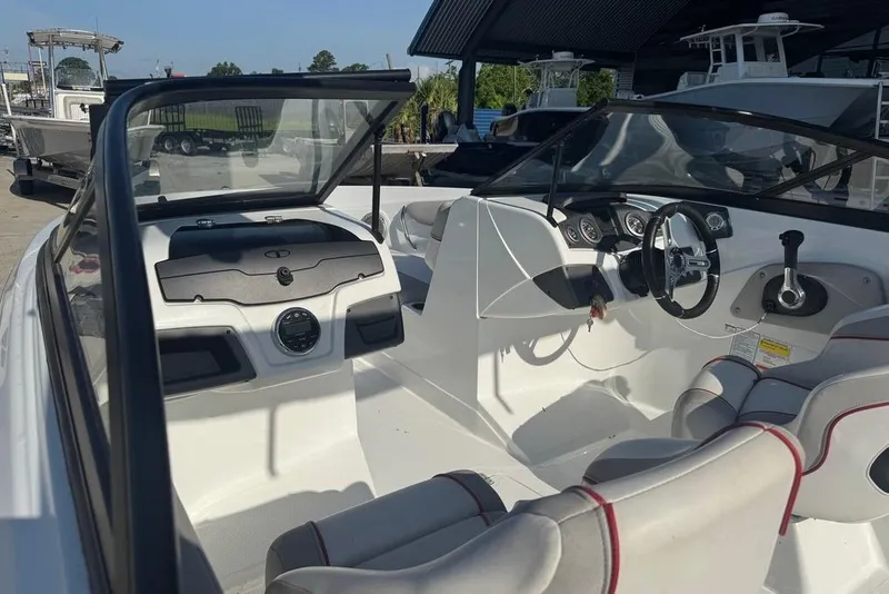 Slide: The Image of 2018 Tahoe 700 TF boat interior with steering wheel and seating, docked outdoors. - 9