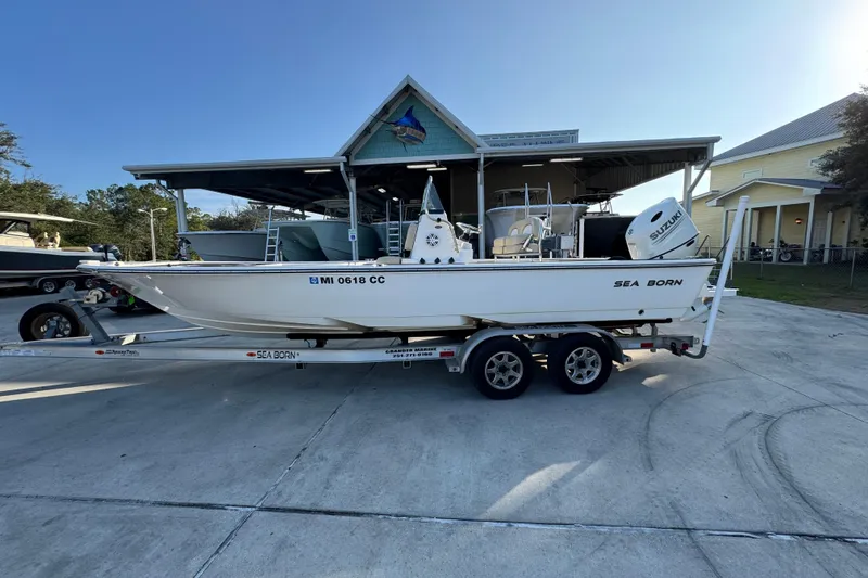 The Image of 2021 Sea Born FX24 Bay boat on trailer, parked outside a building. - 1