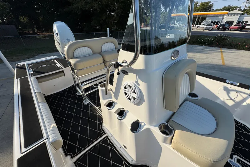 Slide: The Image of 2021 Sea Born FX24 Bay boat interior with seating and console, parked outdoors. - 24