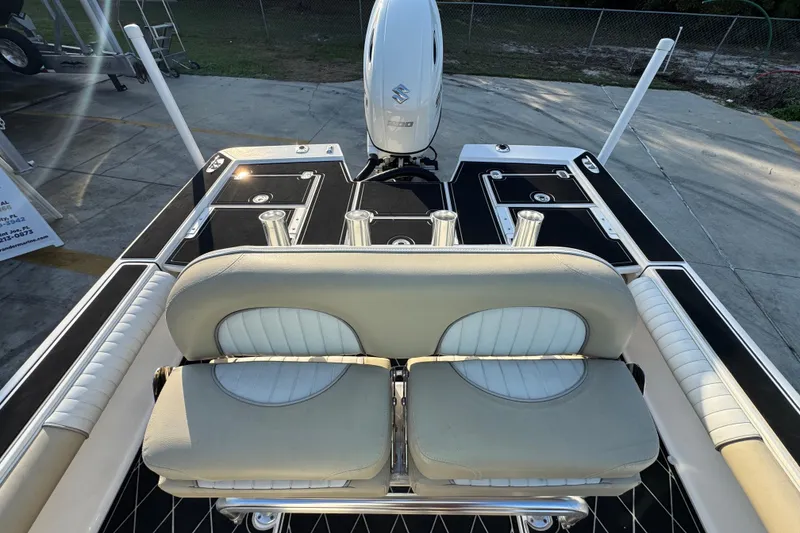 Slide: The Image of 2021 Sea Born FX24 Bay boat interior with seating and motor, docked on concrete. - 26