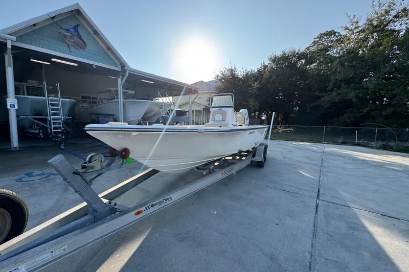 Slide: The Image of 2021 Sea Born FX24 Bay boat on trailer, parked outside a boat storage facility. - 4