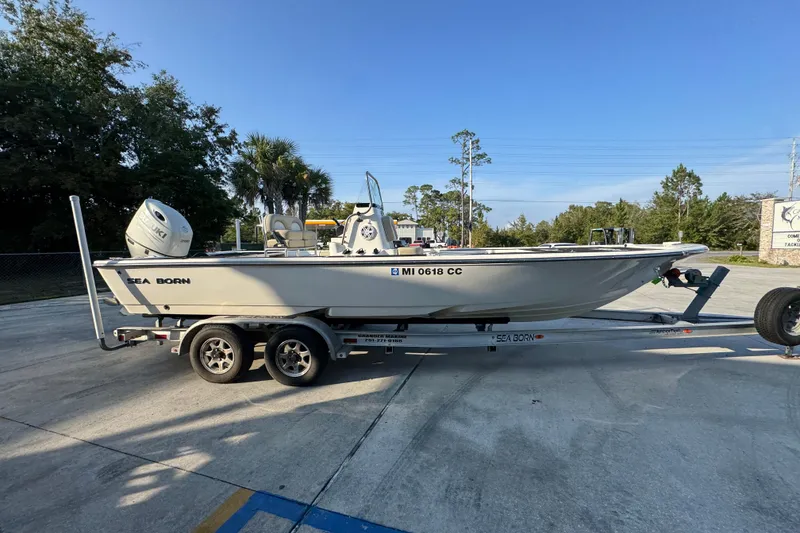 Slide: The Image of 2021 Sea Born FX24 Bay boat on trailer, parked outdoors under clear sky. - 9