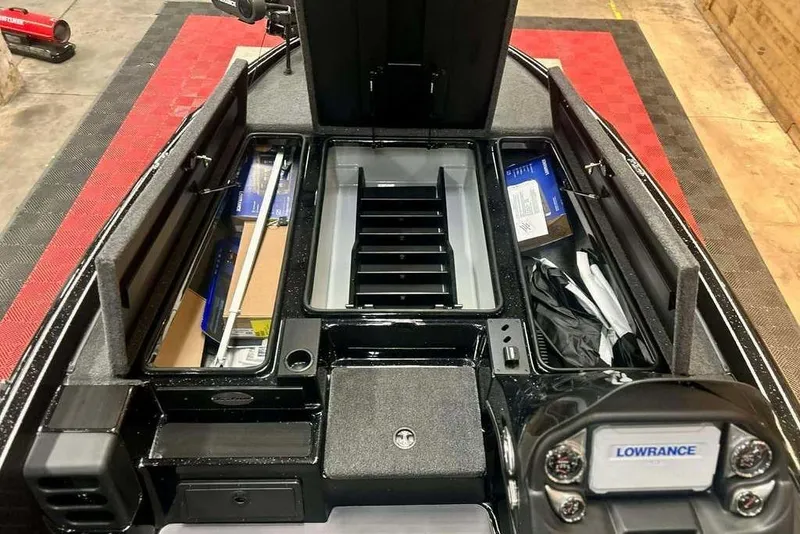 Slide: The Image of 2026 Triton 19 TrX Patriot boat interior with storage compartments and Lowrance electronics. - 11