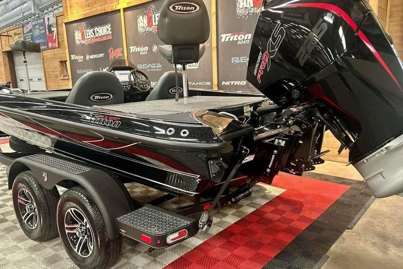 Slide: The Image of 2026 Triton 19 TrX Patriot boat with powerful engine, displayed indoors on a checkered floor. - 6