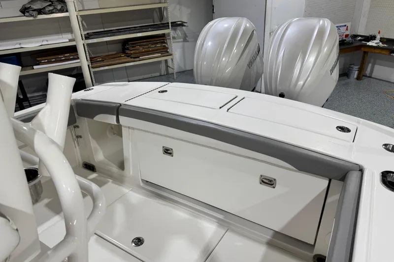 Slide: The Image of 2023 Regulator 28 boat interior with storage compartments and dual outboard engines. - 13