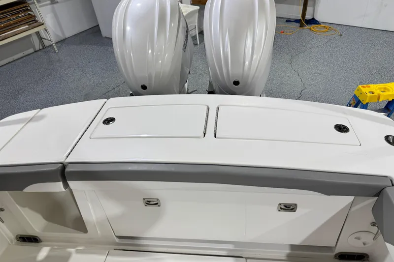 Slide: The Image of 2023 Regulator 28 boat with dual outboard engines in a garage setting. - 14