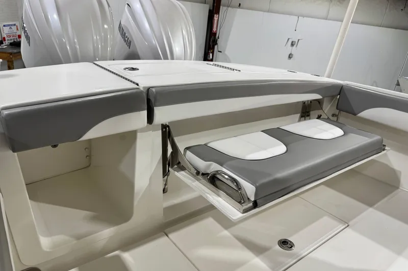 Slide: The Image of 2023 Regulator 28 boat with foldable seating and Yamaha engines in a showroom. - 15