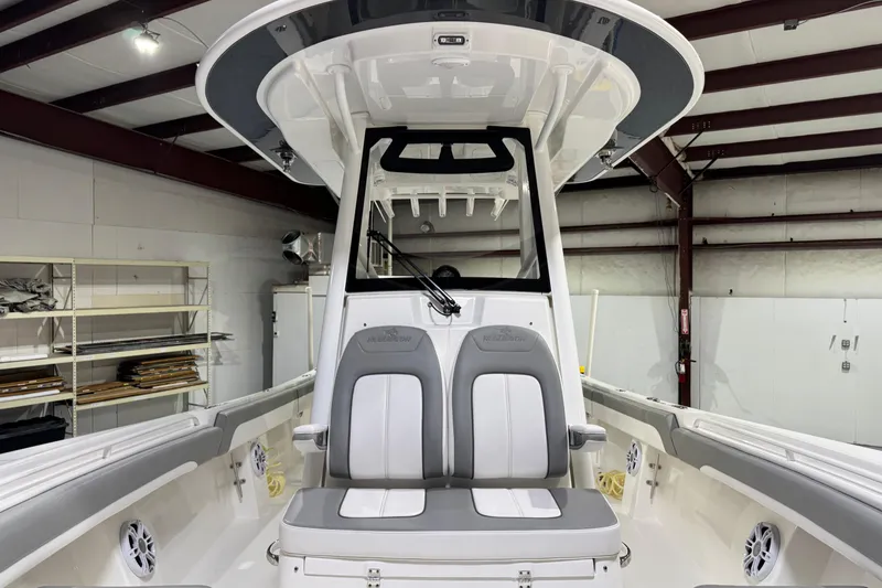 Slide: The Image of 2023 Regulator 28 boat interior with dual seats in a warehouse setting. - 18