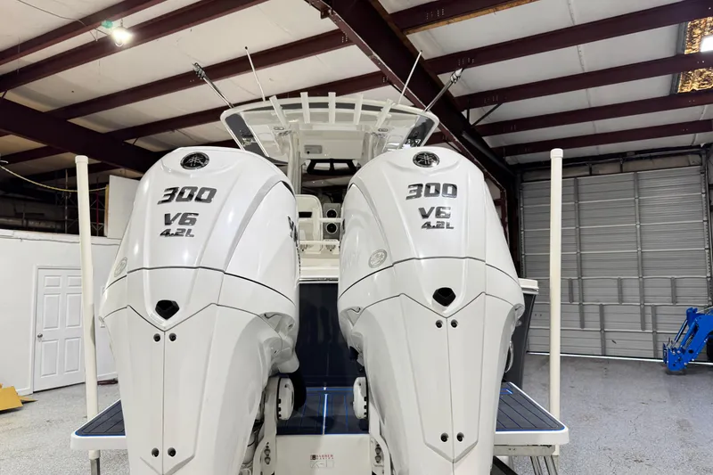 Slide: The Image of 2023 Regulator 28 boat with twin 300 V6 4.2L outboard engines in a garage. - 3