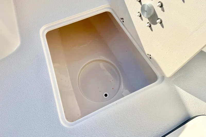 Slide: The Image of Storage compartment on 2026 Carolina Skiff 24 Ultra Elite boat, featuring a clean, white interior. - 16