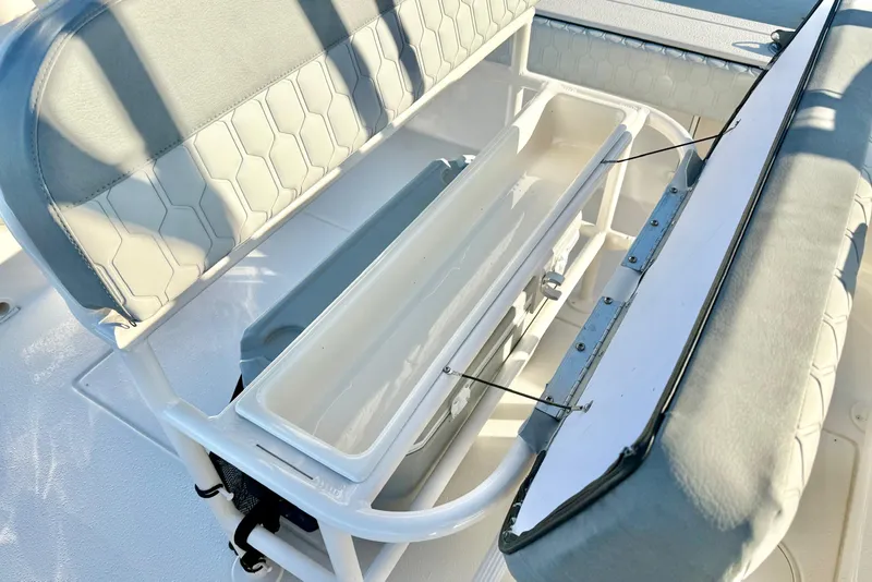 Slide: The Image of 2026 Carolina Skiff 24 Ultra Elite boat seating with storage compartment open. - 28