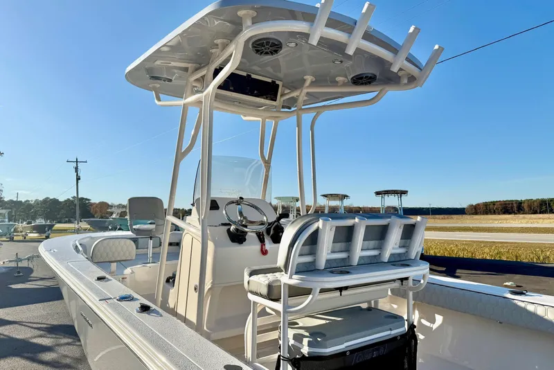 Slide: The Image of 2026 Carolina Skiff 24 Ultra Elite boat with T-top and seating, parked outdoors. - 42