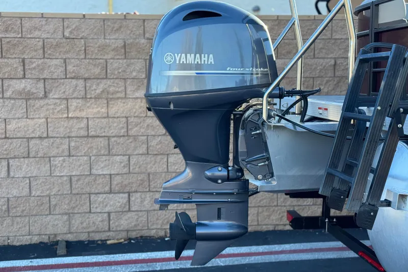 Slide: The Image of 2023 Bennington 22 XSR with Yamaha four-stroke outboard motor, parked by brick wall. - 7