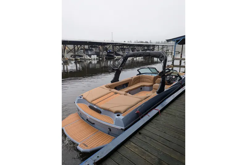 Slide: The Image of 2026 MB B52-23 Classic LIMITED boat docked, featuring luxurious tan seating and sleek design. - 20