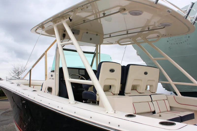 Slide: The Image of 2013 Pursuit ST 310 Sport boat with seating and canopy, docked under cloudy skies. - 10