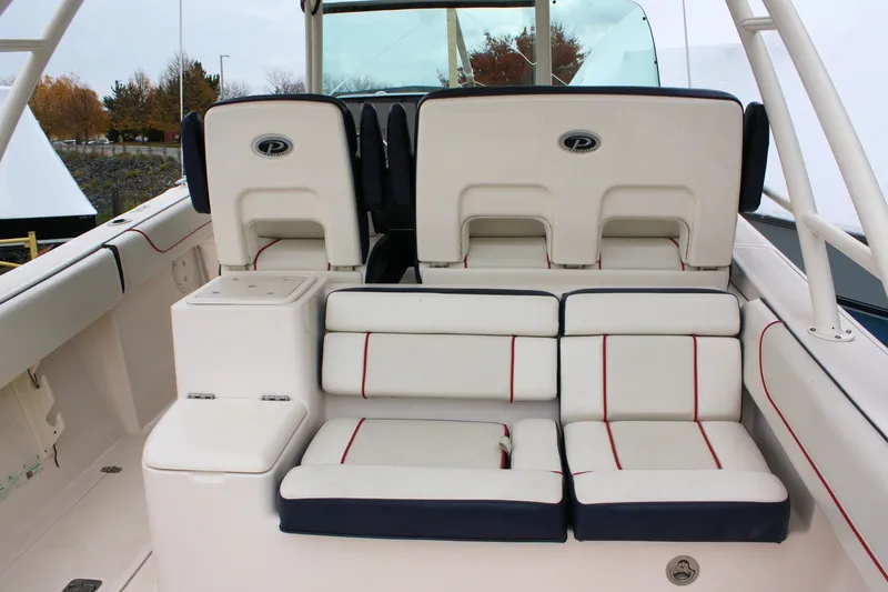 Slide: The Image of 2013 Pursuit ST 310 Sport boat interior with cushioned seating and storage compartments. - 15