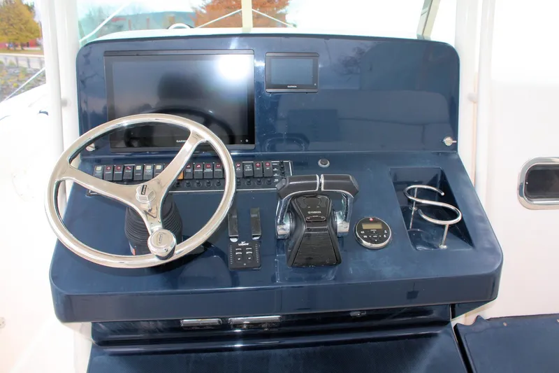 Slide: The Image of Control panel of 2013 Pursuit ST 310 Sport boat with steering wheel and navigation equipment. - 18