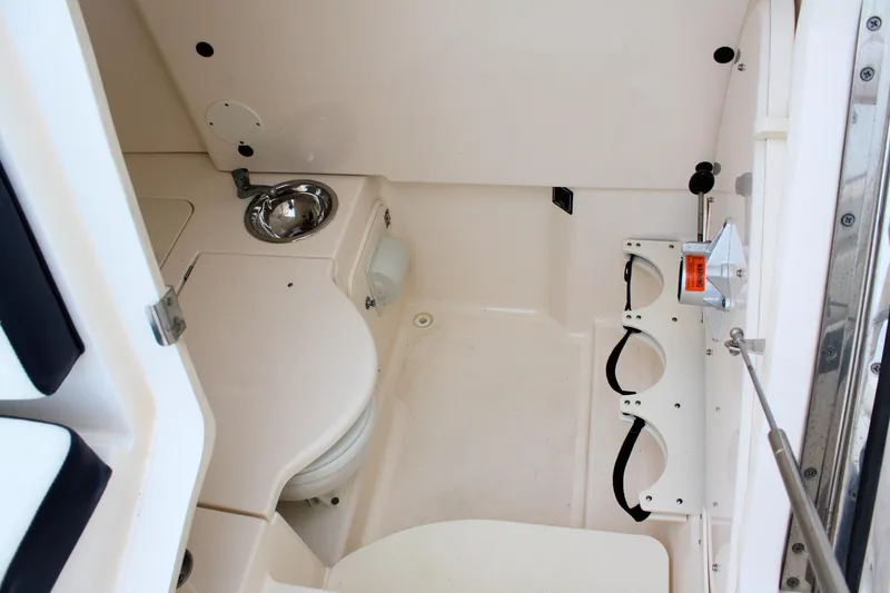 Slide: The Image of 2013 Pursuit ST 310 Sport boat interior with sink and storage compartments. - 20