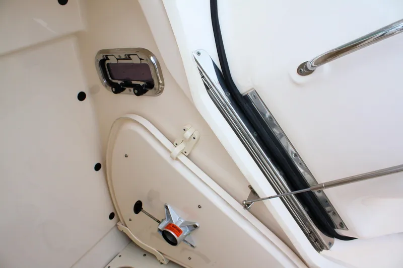 Slide: The Image of Interior view of a 2013 Pursuit ST 310 Sport boat, featuring a hatch and handle. - 22
