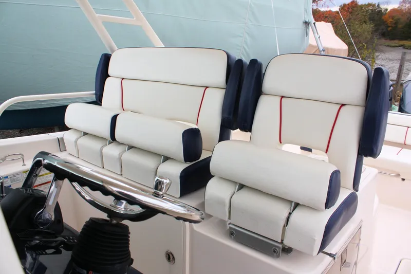 Slide: The Image of 2013 Pursuit ST 310 Sport boat seats with white and navy upholstery. - 23