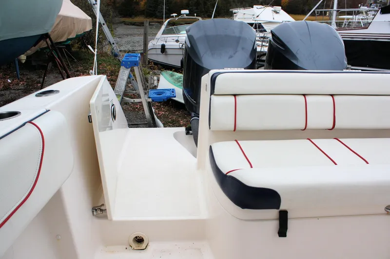 Slide: The Image of 2013 Pursuit ST 310 Sport boat interior with cushioned seating and dual engines. - 29