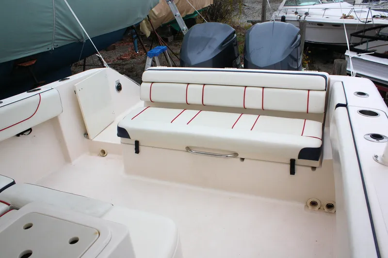Slide: The Image of 2013 Pursuit ST 310 Sport boat interior with cushioned seating and storage compartments. - 30
