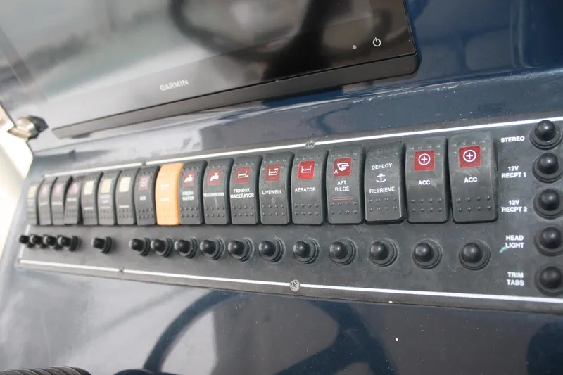 Slide: The Image of Control panel of a 2013 Pursuit ST 310 Sport boat with various switches and buttons. - 33