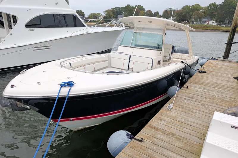 Slide: The Image of 2013 Pursuit ST 310 Sport boat docked at a marina, side view. - 4