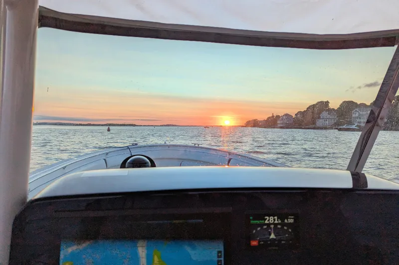 Slide: The Image of 2013 Pursuit ST 310 Sport boat navigating at sunset, scenic waterfront view. - 6
