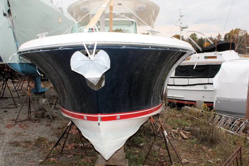 Slide: The Image of 2013 Pursuit ST 310 Sport boat on stands, front view, in a marina setting. - 7