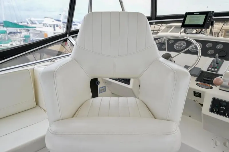 Slide: The Image of 2004 Meridian 490 Pilothouse interior with spacious seating and helm, docked at marina. - 12