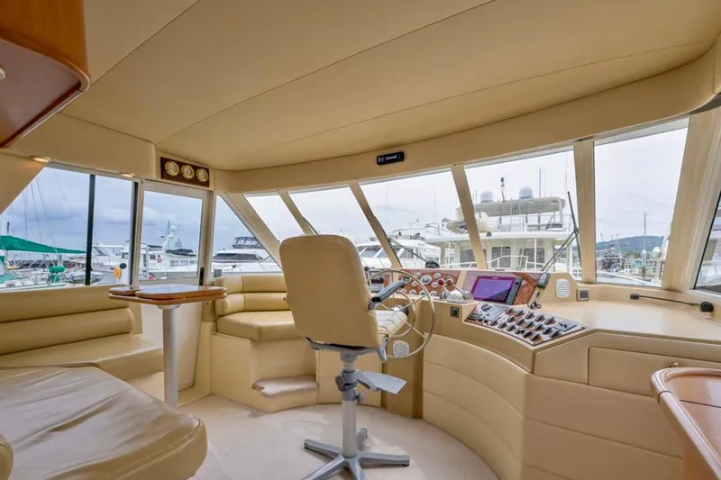 Slide: The Image of Captain's chair in 2004 Meridian 490 Pilothouse yacht cockpit, featuring navigation controls. - 15