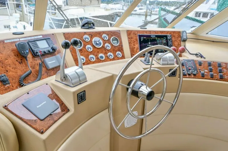 Slide: The Image of 2004 Meridian 490 Pilothouse interior with white seating and marina view. - 17