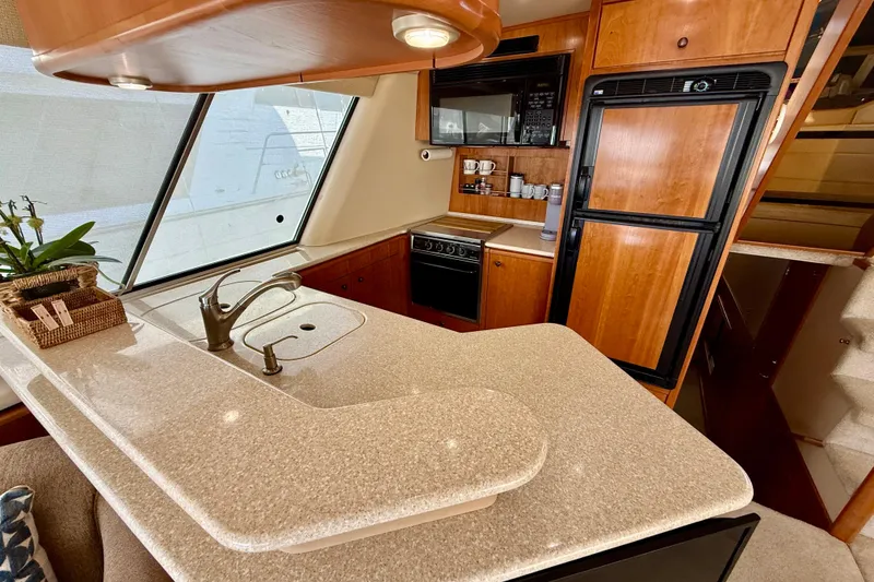 Slide: The Image of Luxurious interior of a 2004 Meridian 490 Pilothouse yacht with elegant seating and kitchen area. - 33