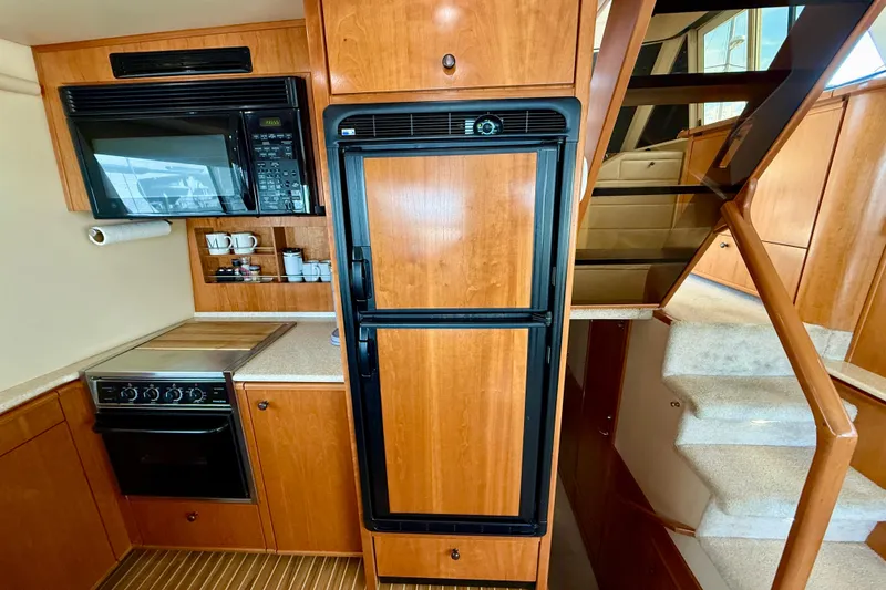 Slide: The Image of Interior of 2004 Meridian 490 Pilothouse yacht with wood cabinetry and beige seating. - 34