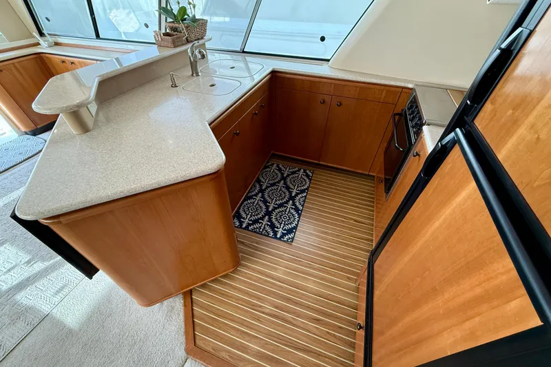 Slide: The Image of Luxurious 2004 Meridian 490 Pilothouse yacht kitchen with wood cabinetry and modern appliances. - 35