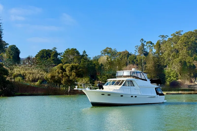 Slide: The Image of Meridian 490 Pilothouse 2004 on calm water with wooded backdrop. - 5