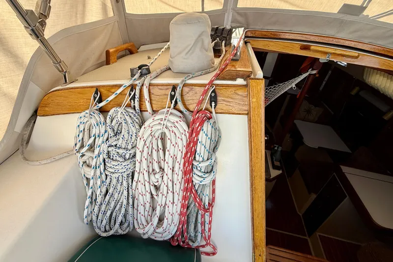 Slide: The Image of Coiled ropes on 1988 Catalina 36 sailboat deck, showcasing nautical equipment and woodwork. - 10