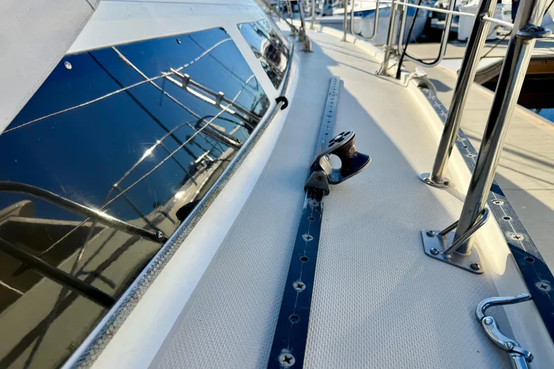 Slide: The Image of 1988 Catalina 36 sailboat deck with polished fittings and reflective windows. - 19