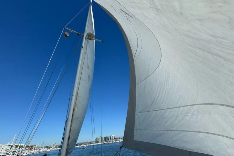 Slide: The Image of Sailing on a 1988 Catalina 36 with full sails against a clear blue sky. - 25