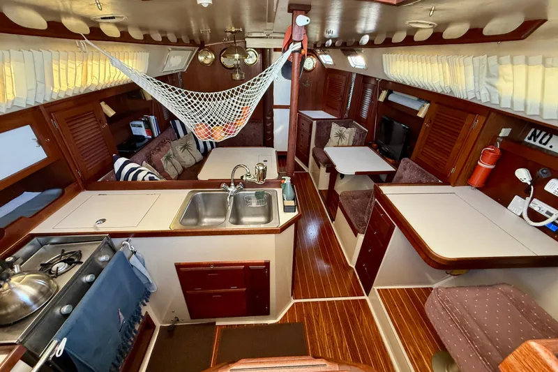Slide: The Image of Interior of a 1988 Catalina 36 sailboat with cozy seating and kitchen area. - 26