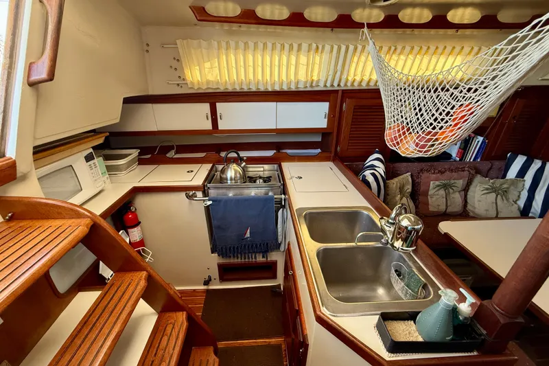 Slide: The Image of Interior of 1988 Catalina 36 sailboat kitchen with sink, stove, and seating area. - 30
