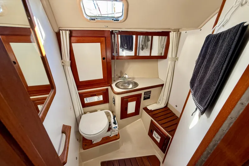 Slide: The Image of 1988 Catalina 36 yacht bathroom with wooden accents, sink, and toilet. - 35