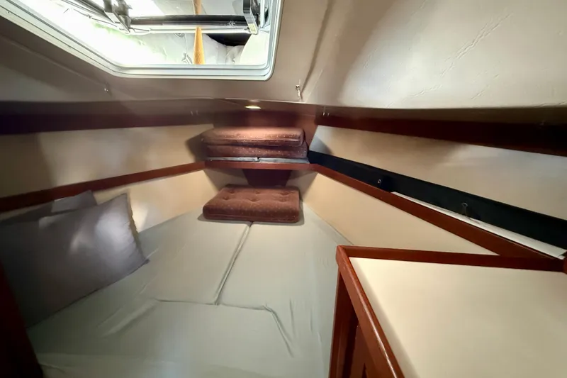 Slide: The Image of Cozy cabin interior of a 1988 Catalina 36 sailboat with cushions and bedding. - 36