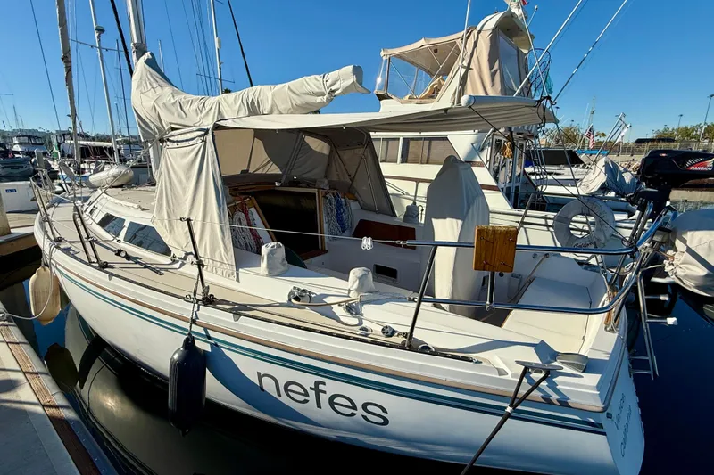 Slide: The Image of 1988 Catalina 36 sailboat docked, covered sails, and visible cockpit area. - 5