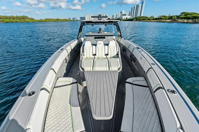 Slide: The Image of 2022 Midnight Express 43' Solstice luxury boat on calm water with city skyline. - 26