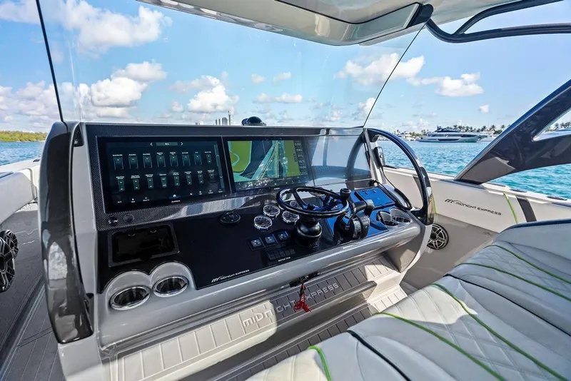Slide: The Image of 2022 Midnight Express 43' Solstice boat dashboard with advanced navigation system on open water. - 37