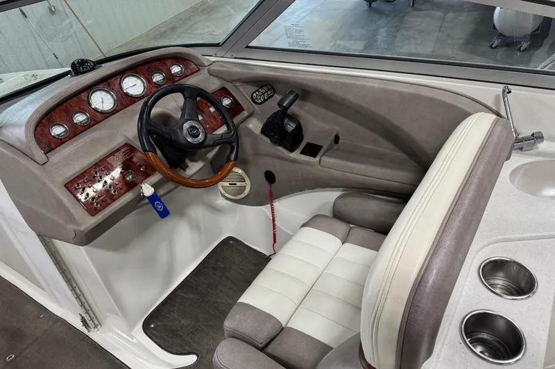 Slide: The Image of 2005 Cobalt 282 boat cockpit with steering wheel, gauges, and beige seating. - 11